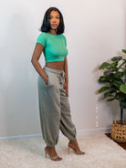 Sage green soft knit jogger pants with a slouchy fit, side pockets, elastic waist with drawstring, and cuffed ankles for cozy, casual wear.