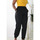 Black sweatpants with side pockets, 2-inch elastic waistband, and elastic cuffs at the ankles, made from 60% cotton and 40% polyester for a comfortable, casual style. Model is 5'4" wearing a small. Front view