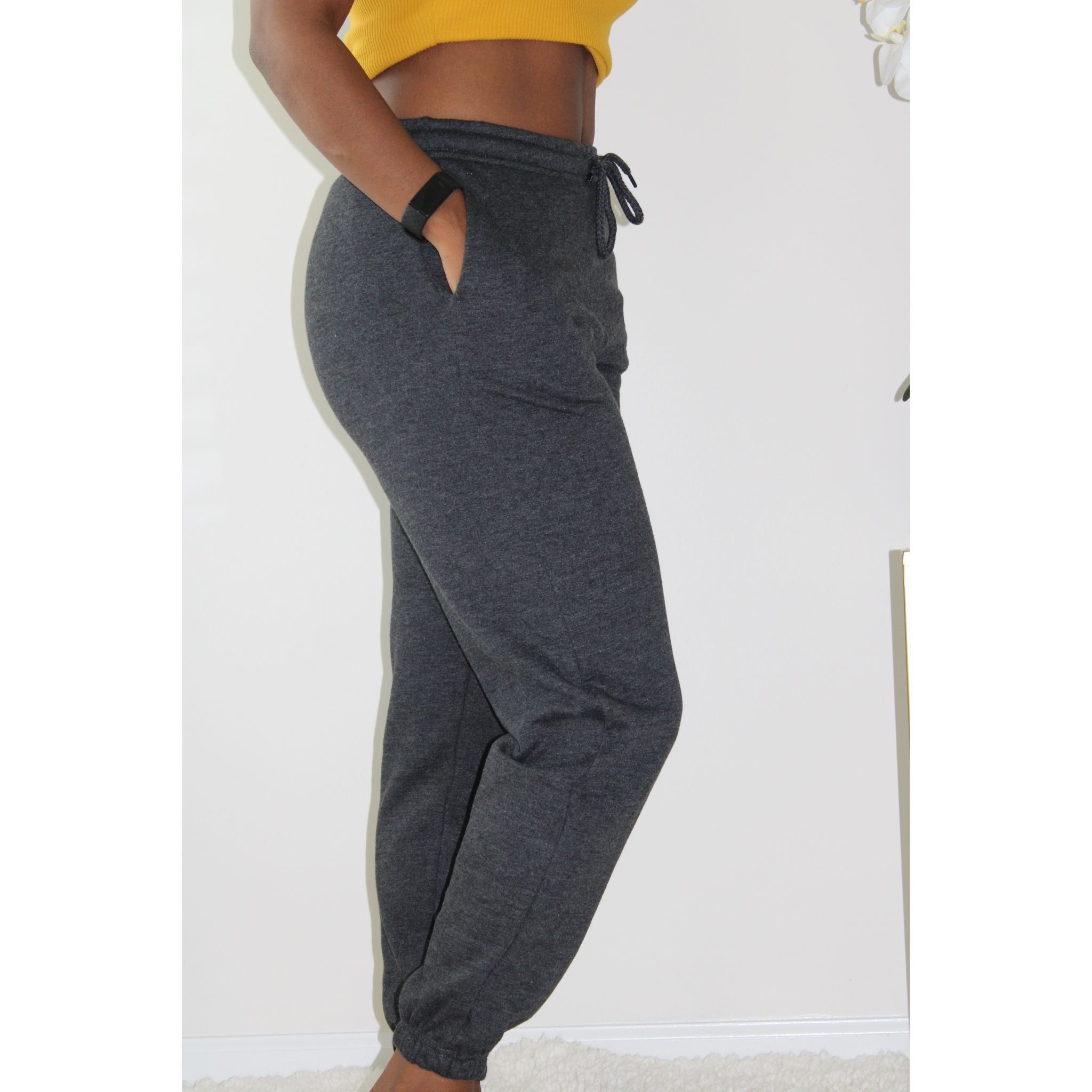 Charcoal sweatpants with side pockets, 2-inch elastic waistband, and elastic cuffs at the ankles, made from 60% cotton and 40% polyester for a comfortable, casual look. Model is 5'4" wearing a small. Right side view