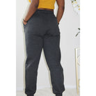 Charcoal sweatpants with side pockets, 2-inch elastic waistband, and elastic cuffs at the ankles, made from 60% cotton and 40% polyester for a comfortable, casual look. Model is 5'4" wearing a small. Hands in pockets side view